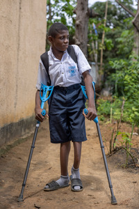 Raphaël, wearing a uniform, sets off to school from his home. © T. Freteur / HI