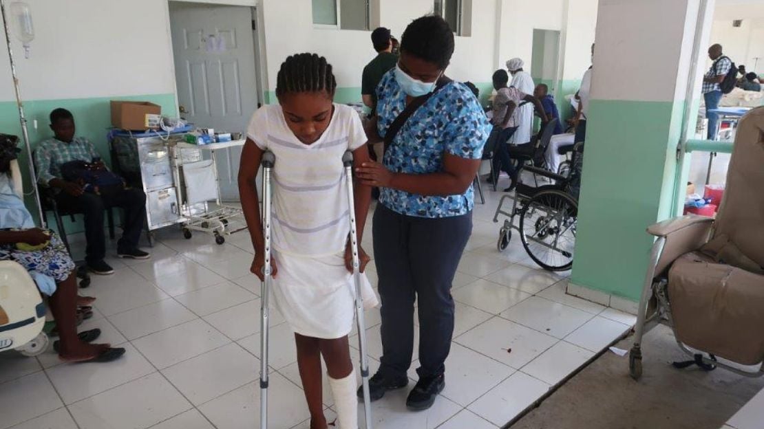 After a fracture caused by the August 14 earthquake, Stephanie learns to walk on crutches with physical therapist Frédia in partnership with HI in the Cayes, Haiti. 2021