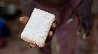 A close up photo of a young child holding up soap.