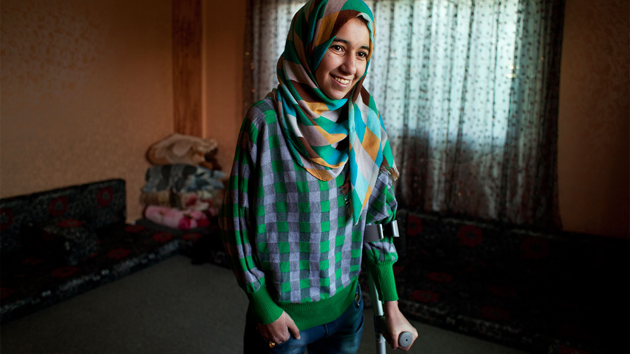 Roqaya lost both legs legs in a bombing in Syria. Handicap International fitted her with artificial limbs and helped her learn to walk again.