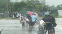 People wade through floods waters on the road from Veechikalmunai to Batticaloa. Sri Lanka.